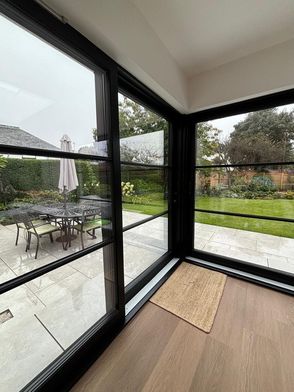 Minimalist slim-profile glazing detail looking onto garden